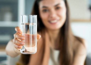 Young woman drinks a glass of water