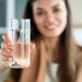 Young woman drinks a glass of water